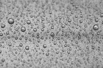 Grainy gray background with water drops. Metallic titanium texture of the pan surface