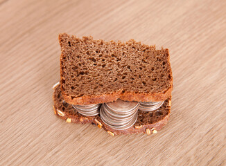 Between two slices of black bread with coins
