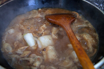Stewed fish cubes in iron pan with miso