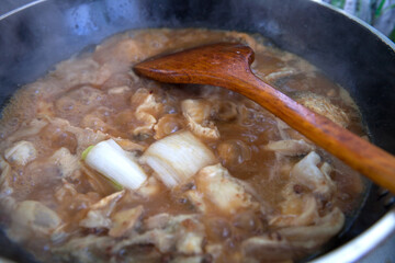Stewed fish cubes in iron pan with miso