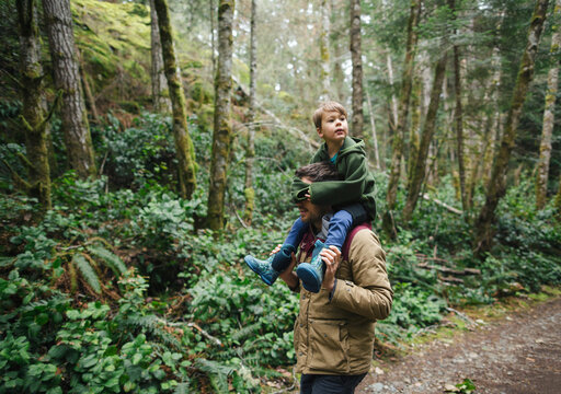Dad giving son piggy back ride in forest blindfolded