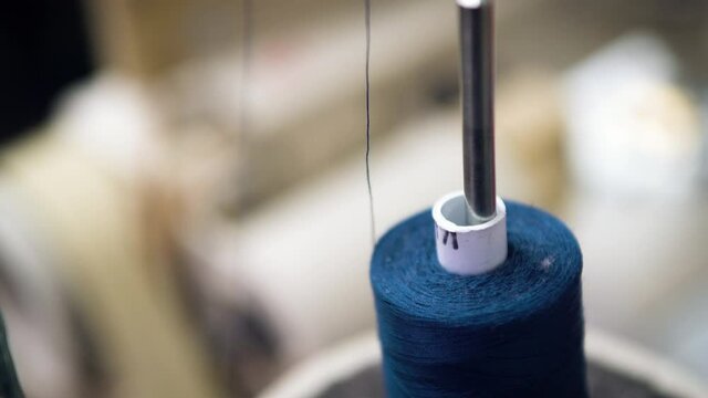 Closeup of a blue thread skein on a sewing machine.