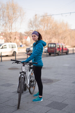 Woman in sporty outfit riding to work with her city bike