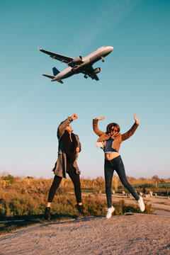 Couple jumping with a plane in the sky