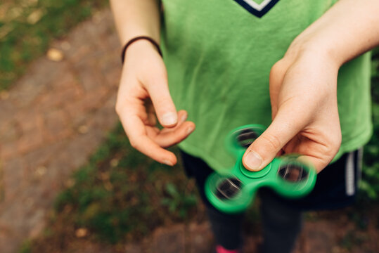 Young girl's hand playing with a fidget spinner