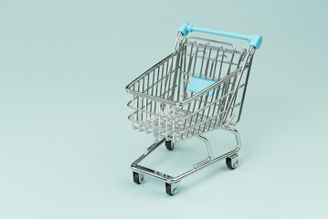 Shopping cart from a supermarket on a light blue background.