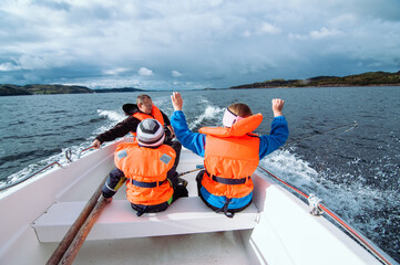 the father with the kids during the boat ride is the sea