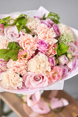 Beautiful spring bouquet on wooden table.. Arrangement with various flowers. The concept of a flower shop. A set of photos for a site or catalogue. Work florist.