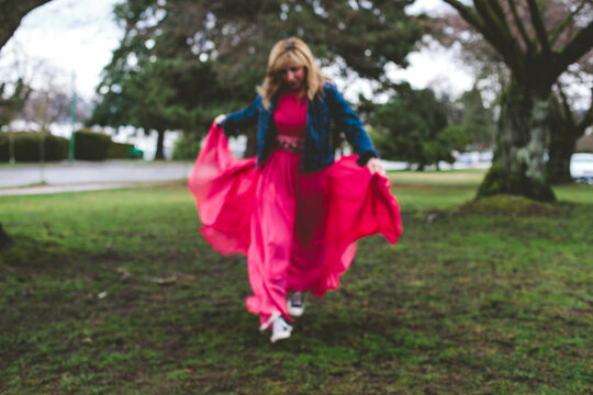 Woman in a pink gown runs free.