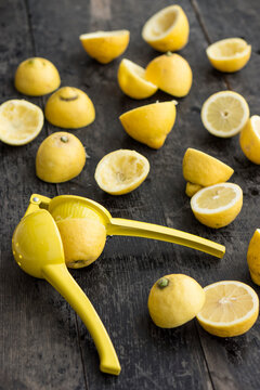Food: Halved and partly squeezed lemons with yellow citrus squeezer