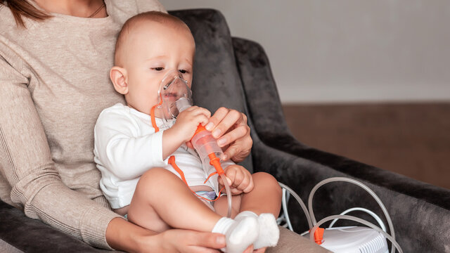 Baby taking respiratory therapy. Hand holding the mask of a nebuliser at home. symptom of asthma or pneumonia cause by respiratory syntactical virus. Health care concept
