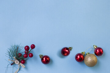 Christmas composition. Frame from branches of a Christmas tree, red and gold decorations on a blue background. Flat lounger, top view, copy space