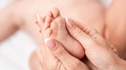 baby feet close up in balck background. Advertising of hygiene, foot diseases, fungus, pedicure, orthopedics. Foot massage for baby. Health care concept