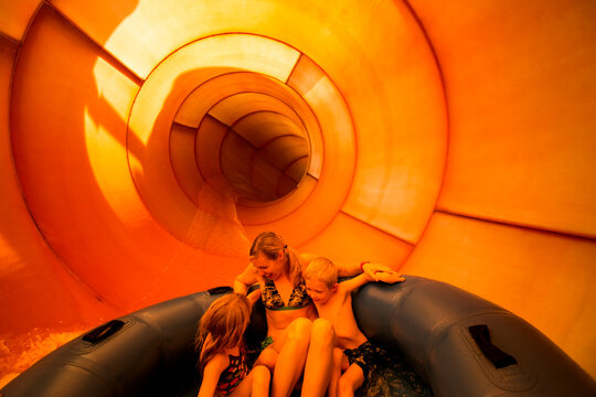Family Speeding Down Giant Water Slide at Theme Park