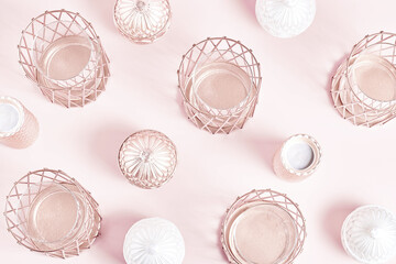 beautiful geometric pattern of candlesticks and candles in rose gold on a pink background. flat lay, top view