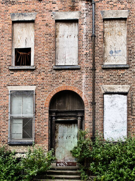 Decaying house with closed up door and windows