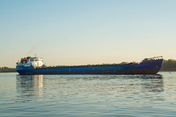 Fototapeta na wymiar Large cargo ship sailing in still water. Cargo ship on the river