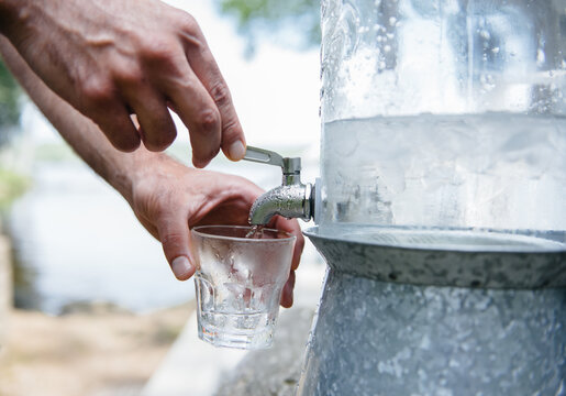 Pouring a drink of ice water from a spout
