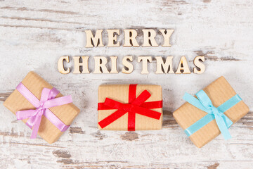 Fototapeta na wymiar Gifts with ribbons and inscription Merry Christmas, festive time concept