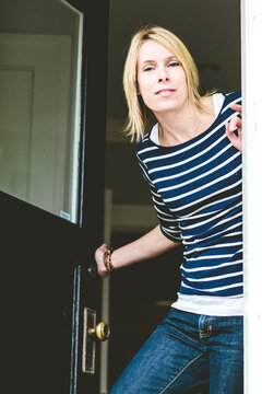 A relaxed looking woman opens the door.