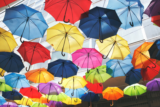 Hundreds of colourful umbrellas float above the street
