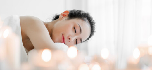 Smiling of young beautiful pretty asian woman clean fresh healthy white skin spa treatment relaxing lying on towel in massaging and spa salon