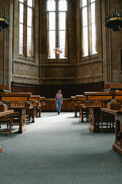 young woman stands in library