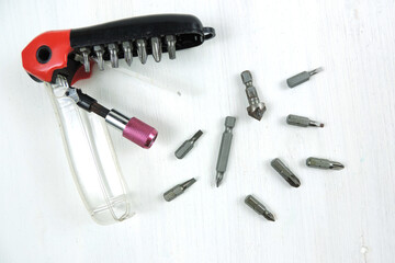    A magnetic quick release bit holder with various screw driving bits and a countersink. white background.             