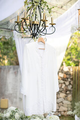 a white wedding dress hanging on the chandelier