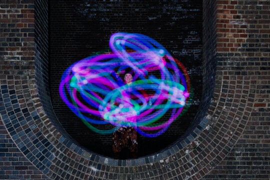 Glowing trails of light made by a Poi dancer using led glow poi's