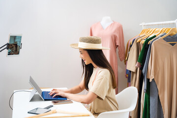 Asian woman selling vintage clothes online is broadcast live in Social Media.She is answering customers questions.