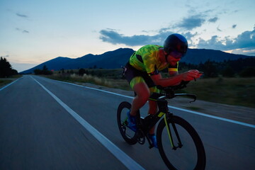 triathlon athlete riding bike at night