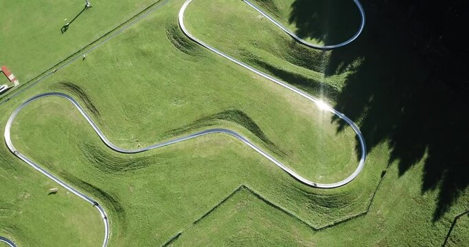 Amazing drone aerial view of a summer bobsleigh track. Passo della Presolana. Bergamo, Italy. Natural contest. Leisure time. Beautiful nature with green meadow. Vertical landscape