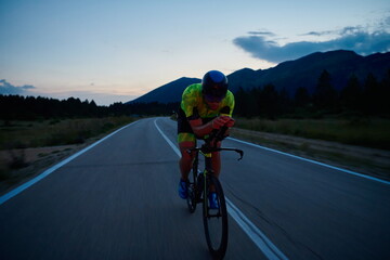 triathlon athlete riding bike at night