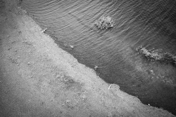 Aerial view of blue lake with green forests with rocks on a summer day
