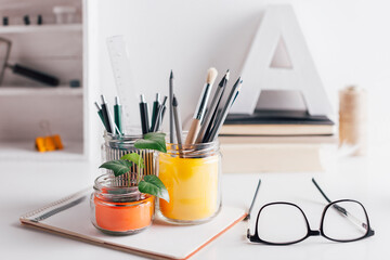 Diy pencil holder jars on a cute white home desk.
