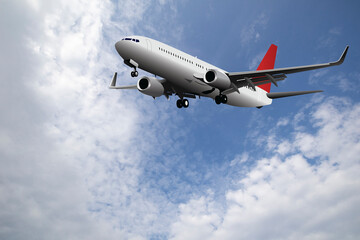 Fototapeta na wymiar Commercial passenger plane with landing gear down set against a blue cloudy daytime sky