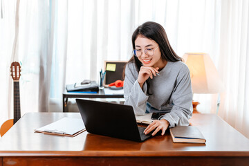 High school or college student learning tutoring on desk and reading, doing homework, lesson practice preparing exam on laptop at home. Education concept.