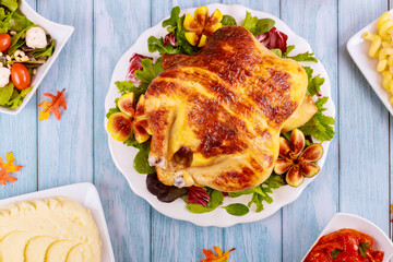 Whole roasted chicken on plate with salad and fig.