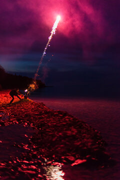 Man Lighting Fireworks at the Beach for Canada Day Celebration