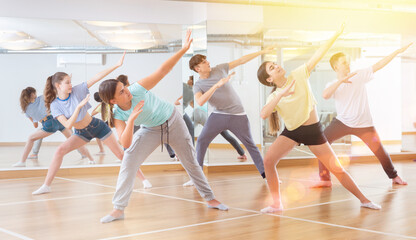 Fototapeta na wymiar Active teens learn new dance moves in dance studio