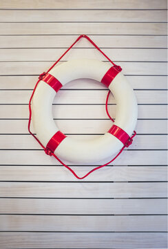 Life preserver over white wooden wall