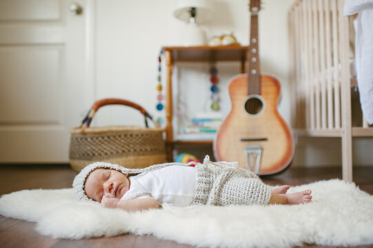 Cute baby laying on lamb rug with crochet clothing