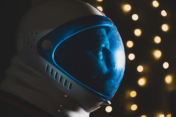 Spaceman wearing astronaut helmet with twinkle lights in the background © Mat Hayward