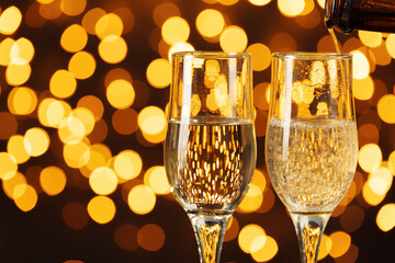 Two glasses of Champagne against bokeh lights background