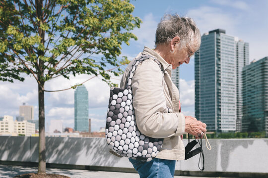 Woman Senior Citizen with old Instamatic Digital Camera Technology Taking Photos of New York City Skyline