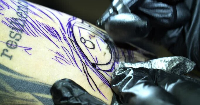 Close-up of a tattooist in gloves doing a tattoo