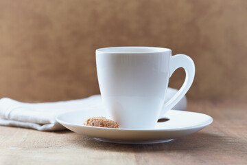 Amaretti (Italian biscuits) and a cup of coffee on rustic wooden background. Close up. 