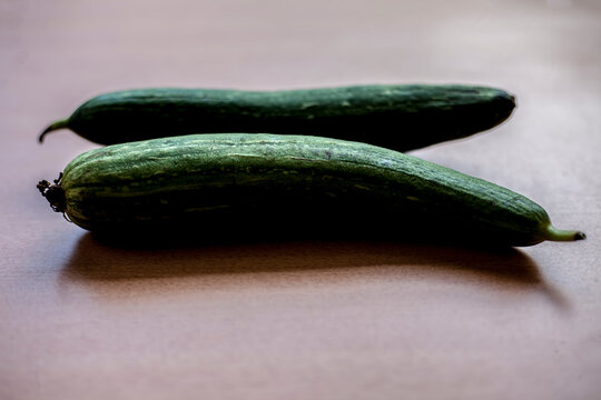 close up shot of raw Galka or sponge gourd on a brown colored wooden surface.