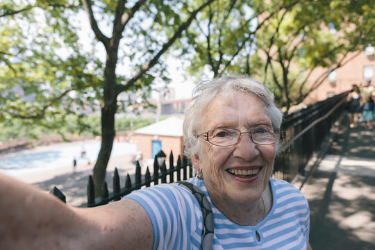 Portrait of Smiling Healthy Senior Citizen Woman Using Camera Technology Taking Selfie Photo on Sunny Day Outdoor